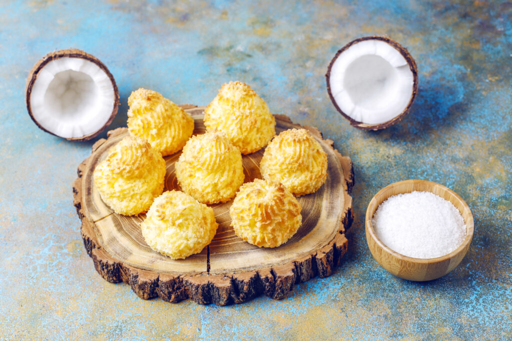 Macaroons surrounded by halved coconut and sugar