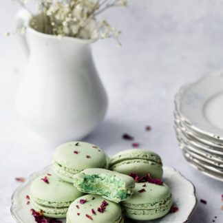 Green macarons with chocolate bits on top